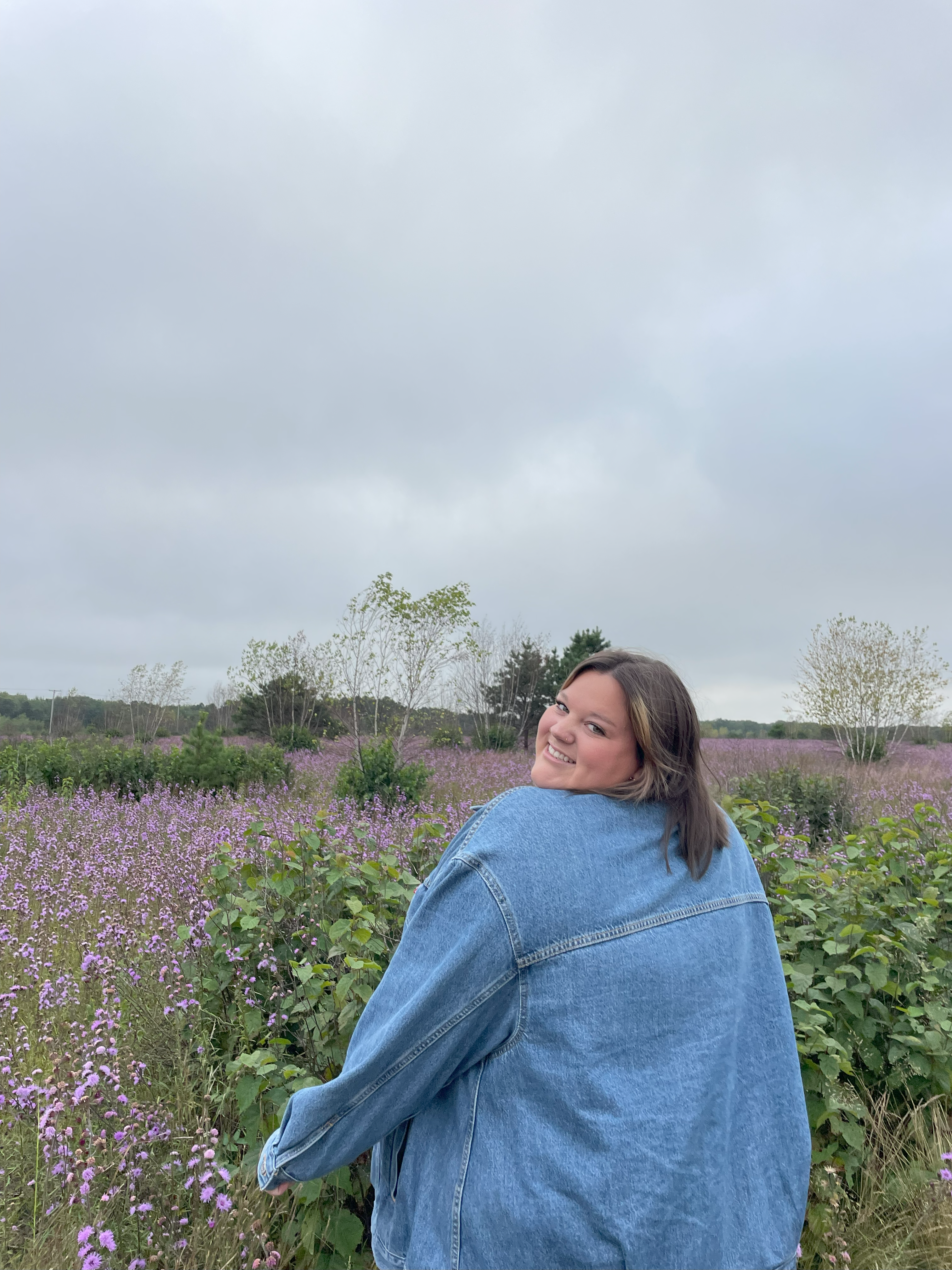 Photo of Lilly Kendall in a field or purple flowers.